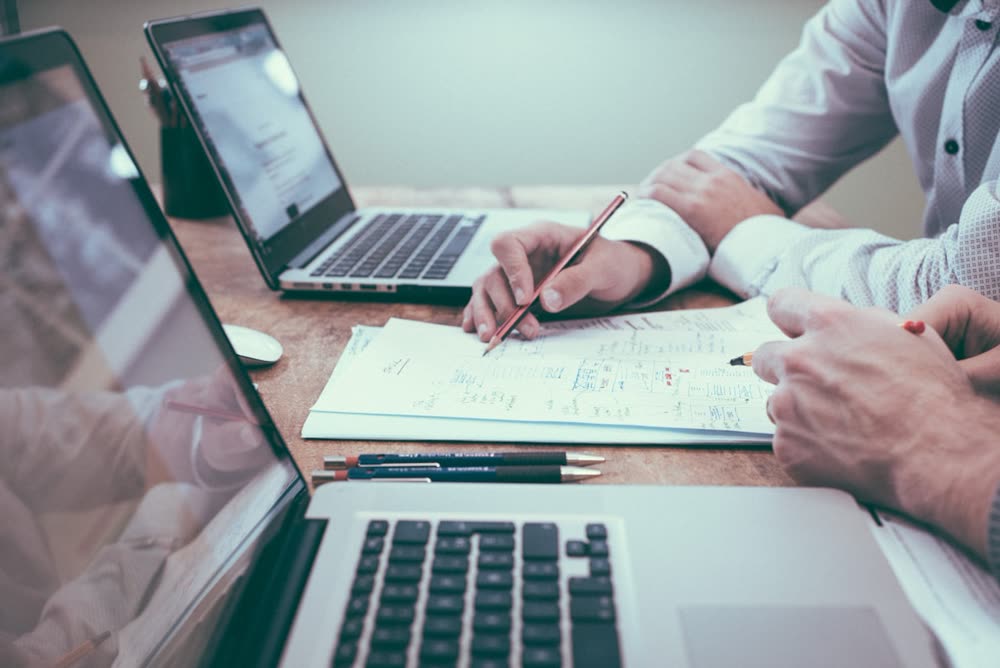 Advisors working through a capital strategy together at a desk